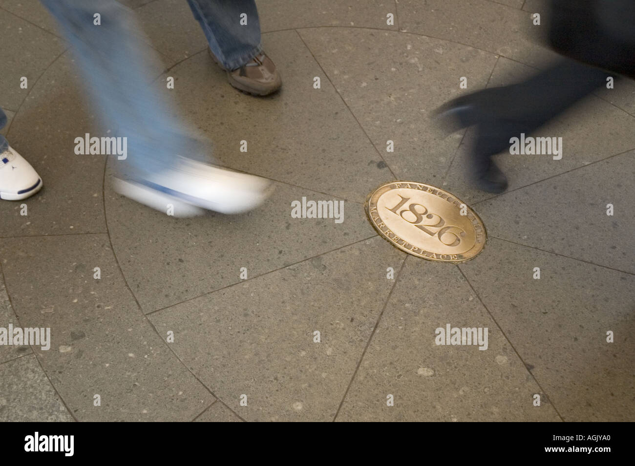 Blurred shoes and legs of tourists and locals as they rush through Faneuil  Hall Marketplace past a golden plaque that reads 1826 Stock Photo - Alamy