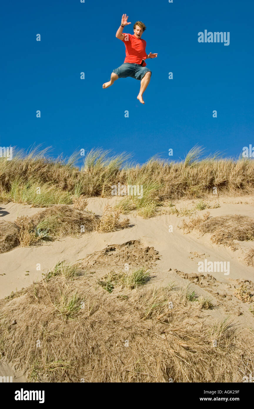 Young Man leaping from a Sand Dune Braunton Burrows Devon UK Stock Photo