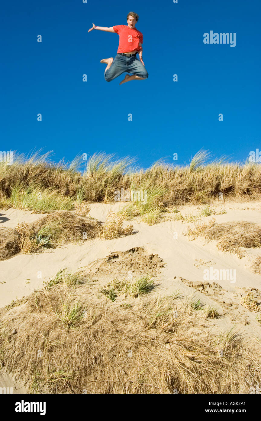 Young Man leaping from a Sand Dune Braunton Burrows Devon UK Stock Photo