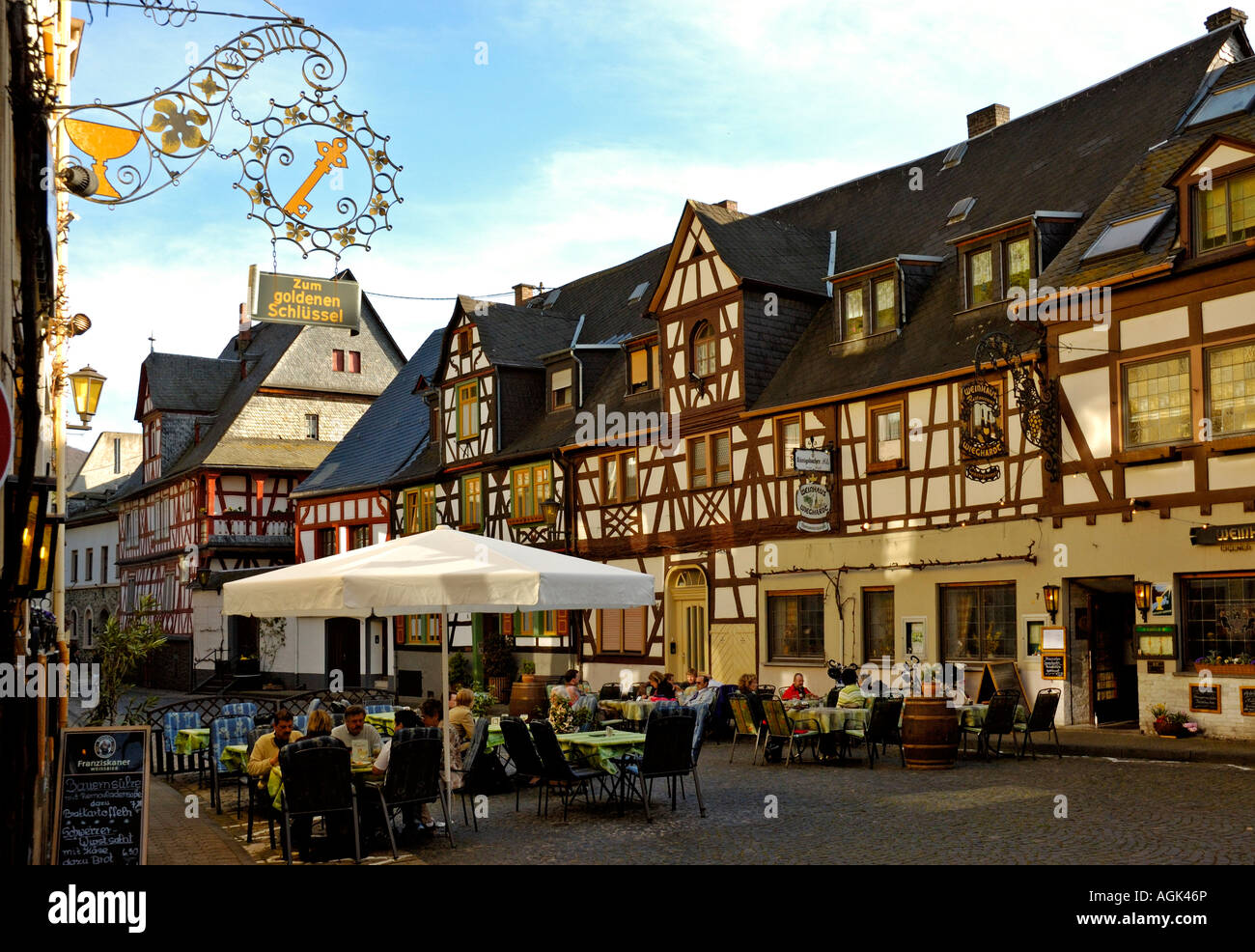 Guests eating & drinking outside 18th century Half-timbered buildings in Braubach, upper middle rhine valley, Germany, Stock Photo