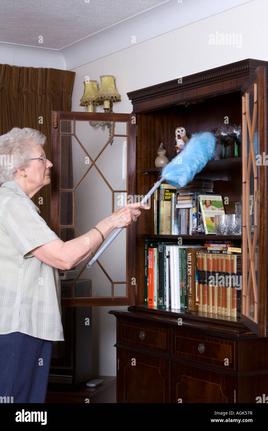 Elderly woman dusting cleaning housework uk hires stock photography