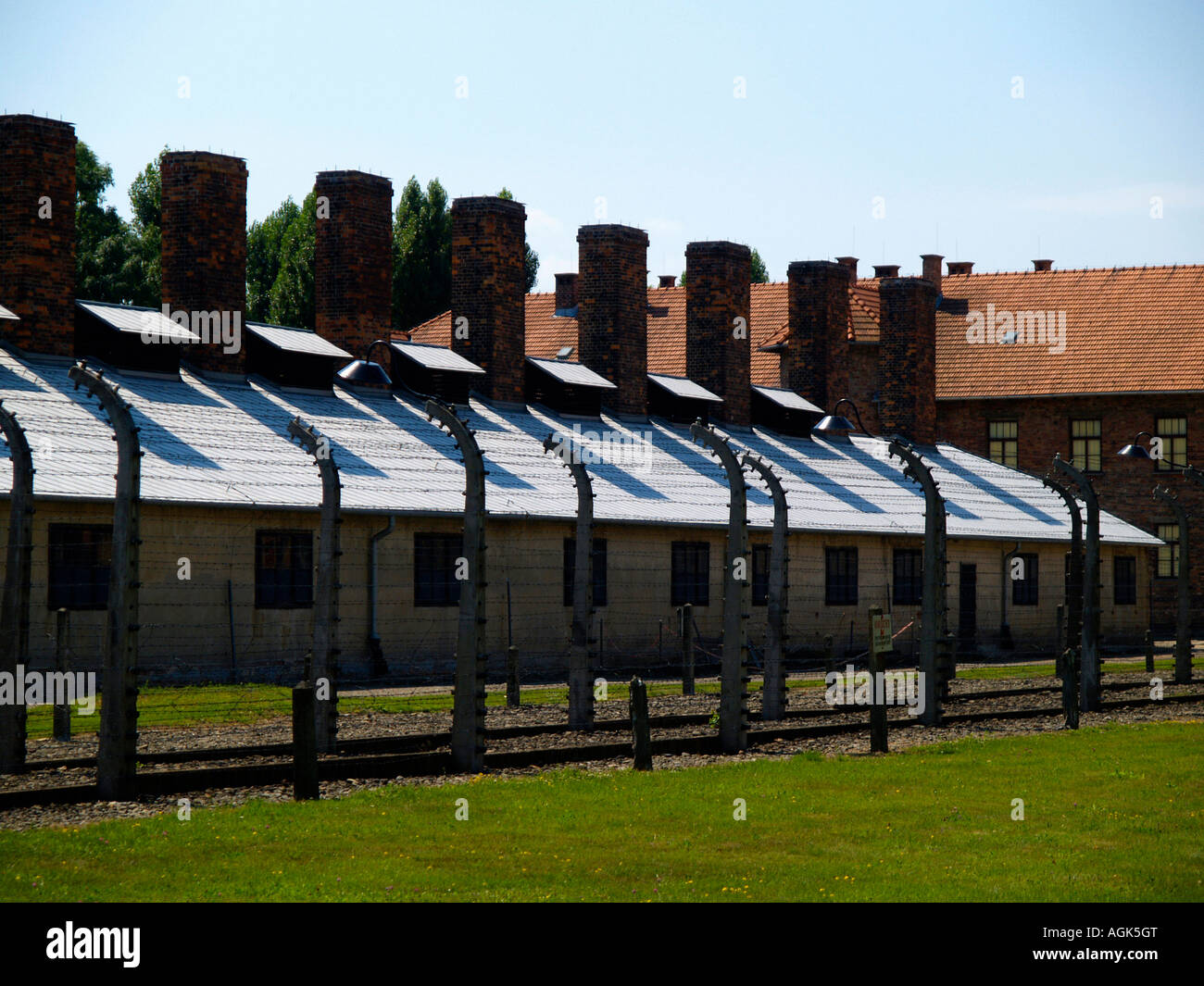 Barbed wire and administrative buildings at the Auschwitz concentration camp outside of Krakow, Poland. Stock Photo