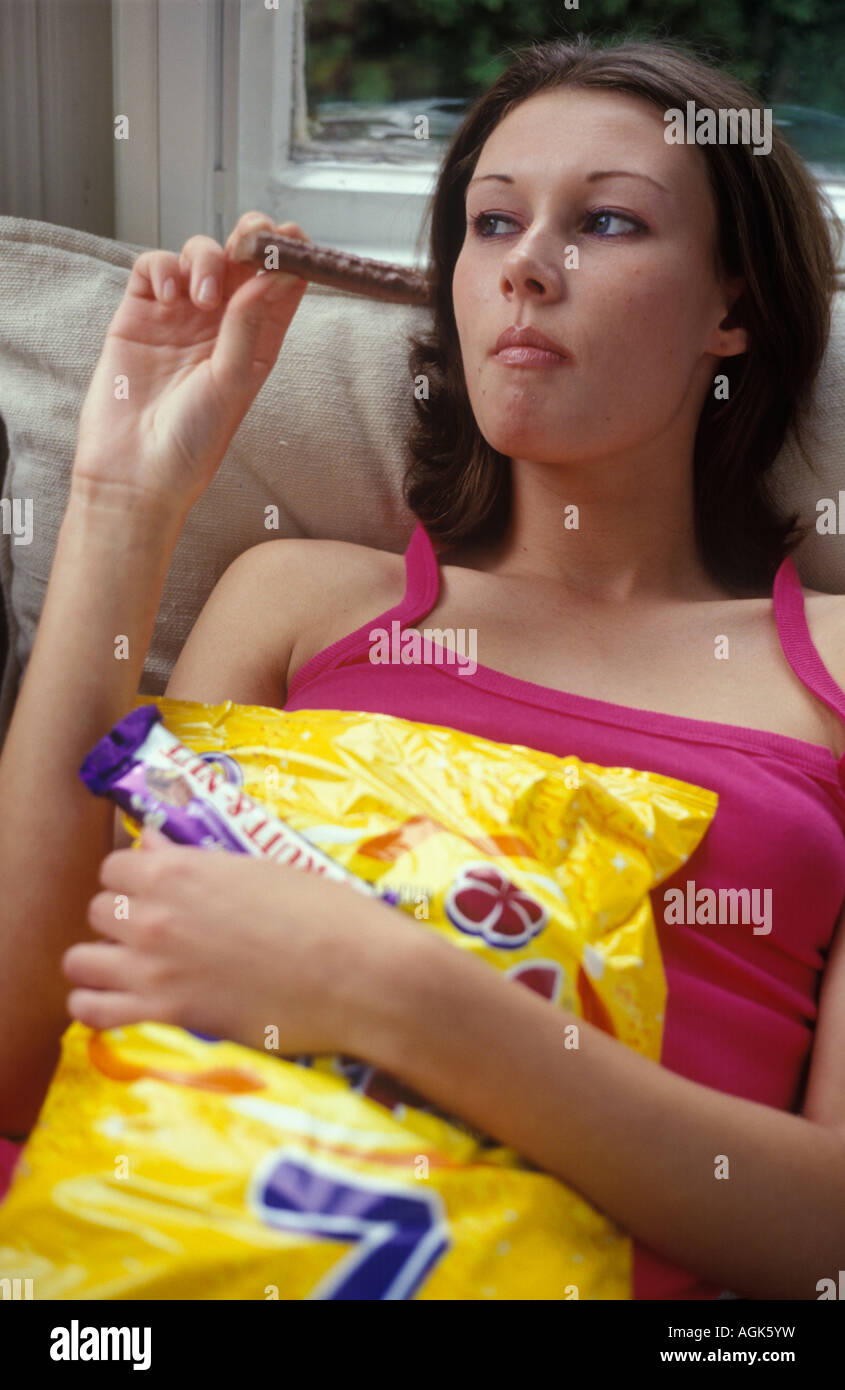 teenage girl bingeing on fun bars of chocolate Stock Photo