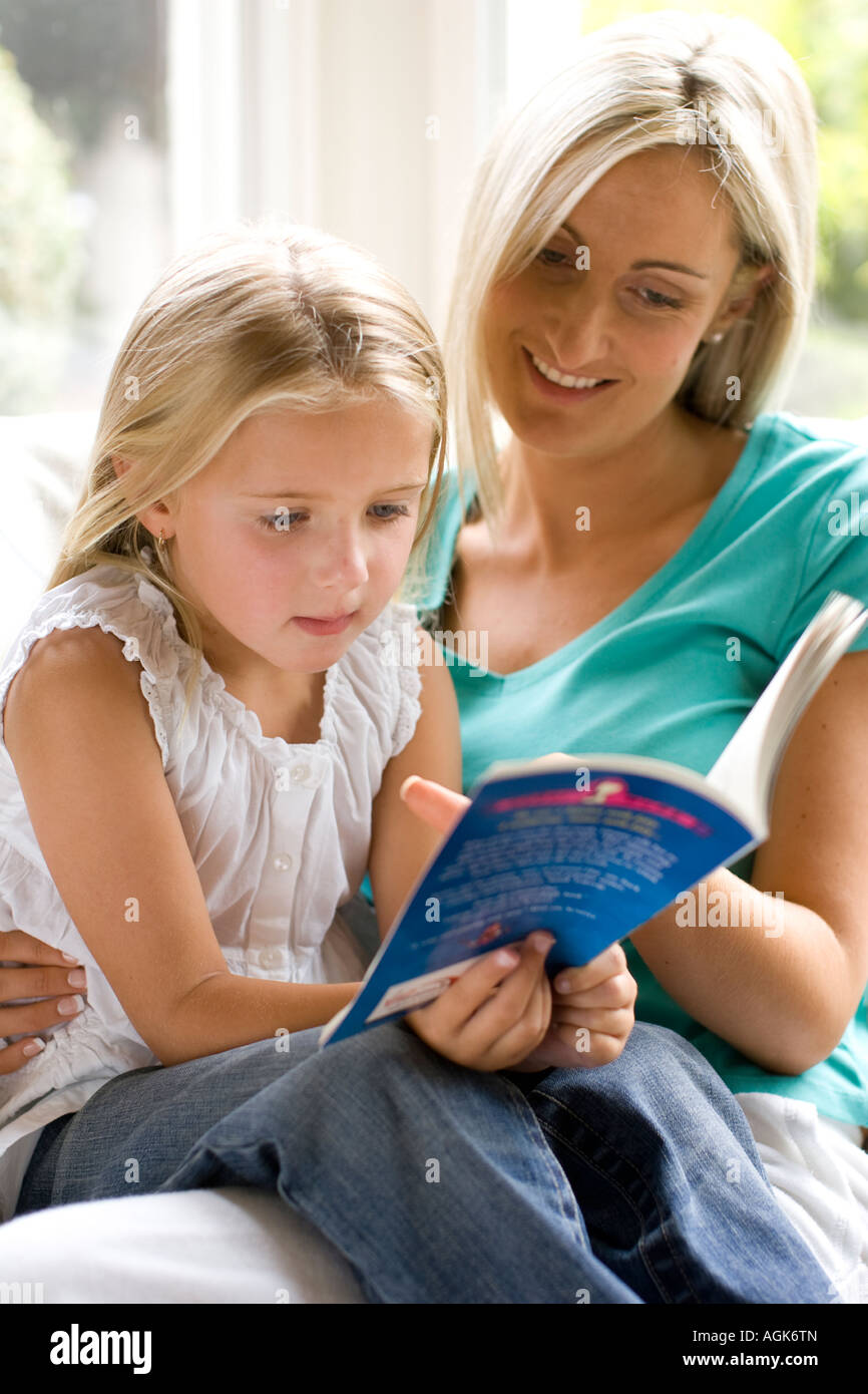 portrait of mother and daughter reading together Stock Photo