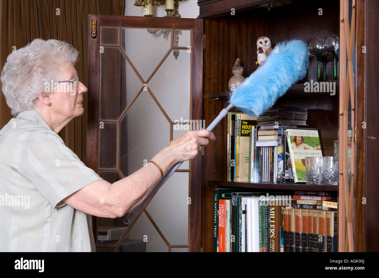 Elderly woman dusting cleaning housework uk hires stock photography