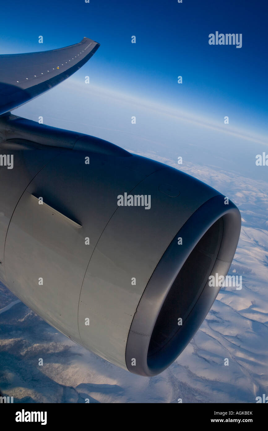 graphic shot of airplane wing and engine taken at sunrise over snowy range Stock Photo