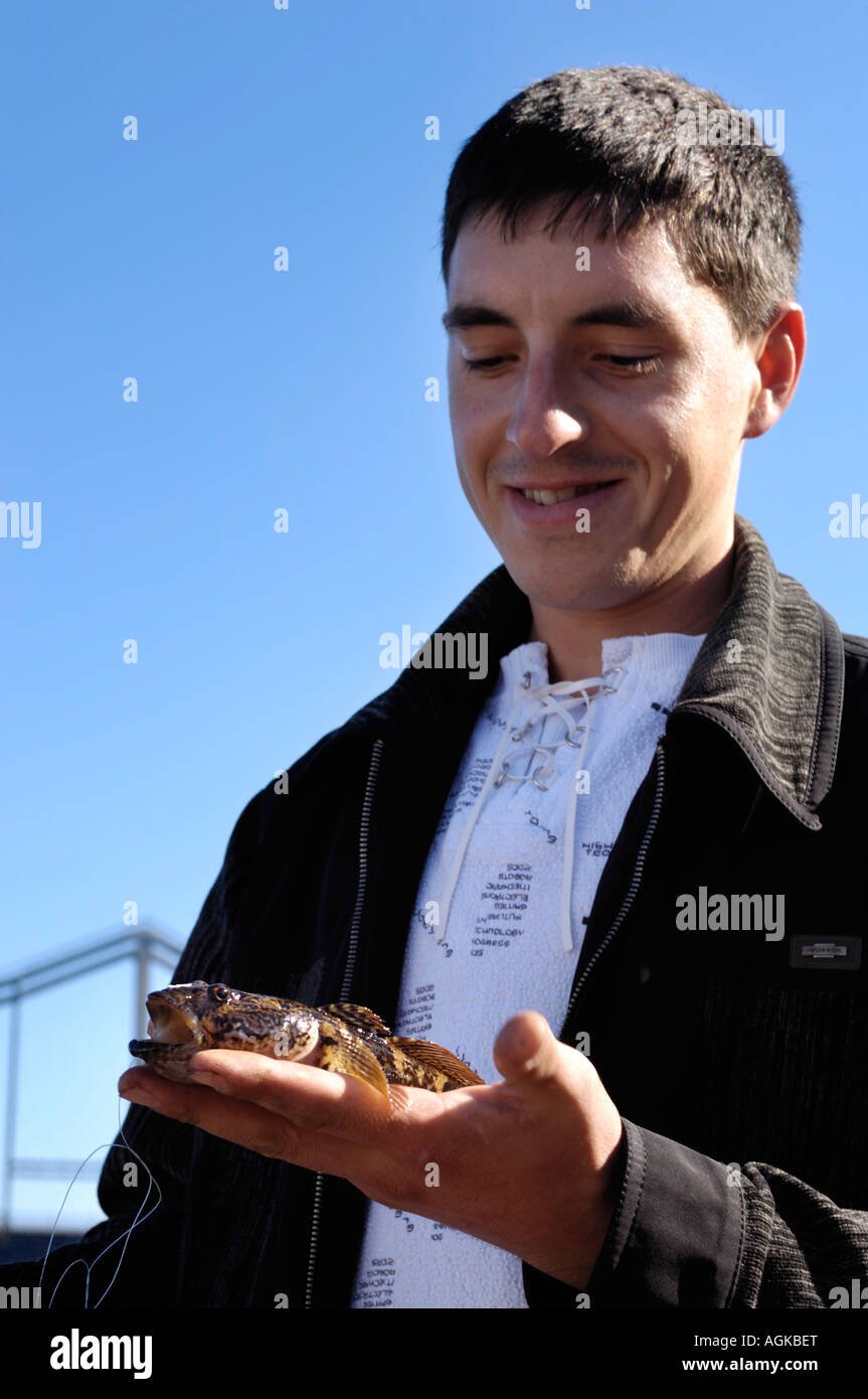 Happy fisherman with goby fish Stock Photo