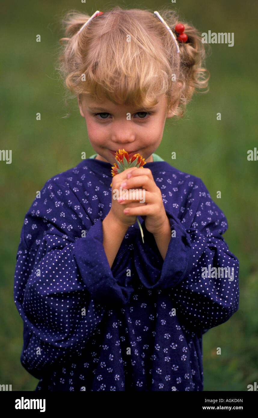Young girl smelling flowers Stock Photo - Alamy
