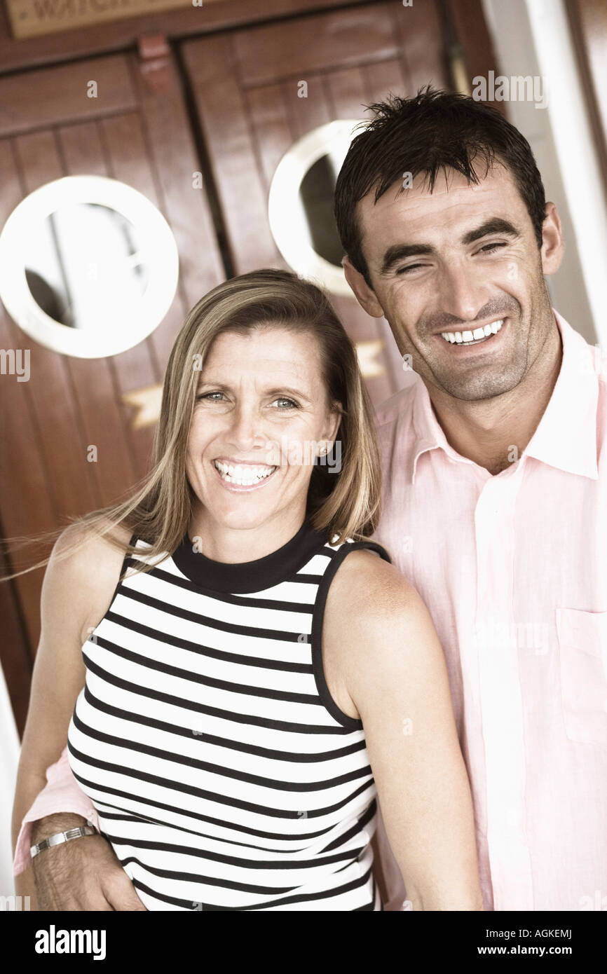 Close-up of a mid adult man with his arm around a mid adult woman and ...