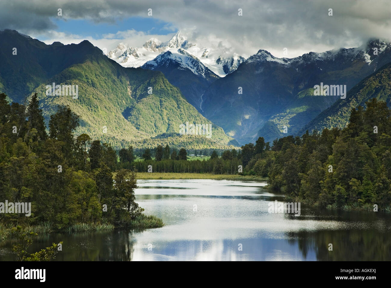 New Zealand, South Island. Cloud-shrouded Mt. Cook is reflected in Lake Matheson near the town of Fox Glacier. Stock Photo