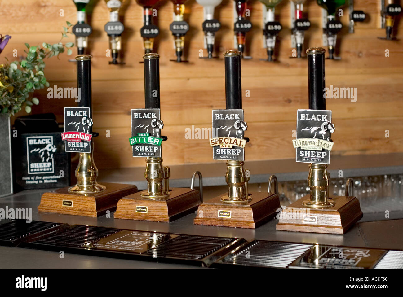 Beer pumps on a pub bar counter with optics in background at Black Sheep Brewery, Yorkshire, England, UK Stock Photo