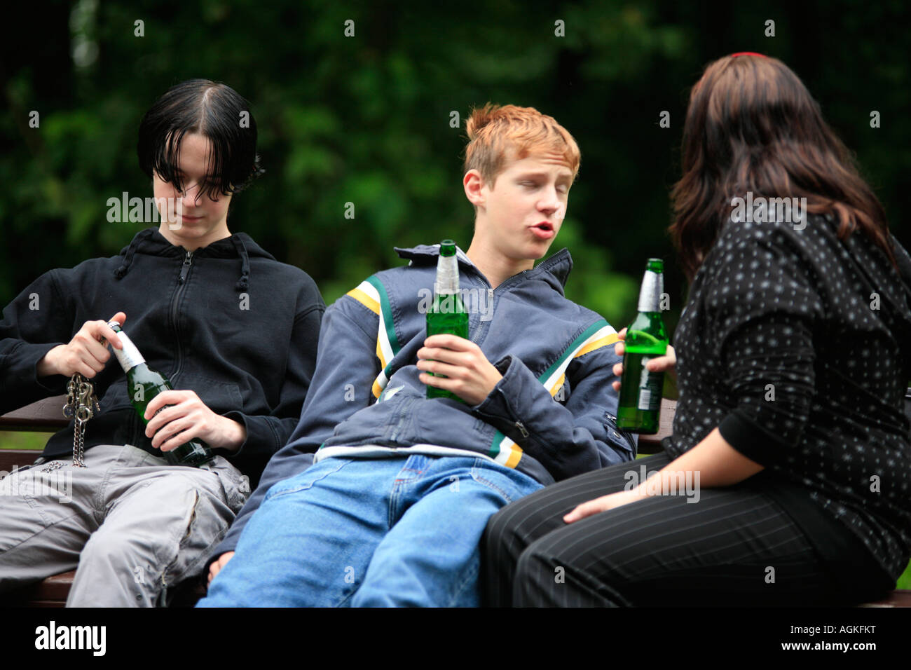 three teenagers drinking beer at a park Stock Photo Alamy