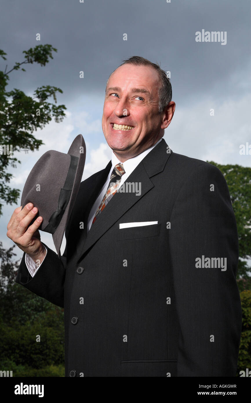 Old fashioned cheeky chap hold a hat Stock Photo