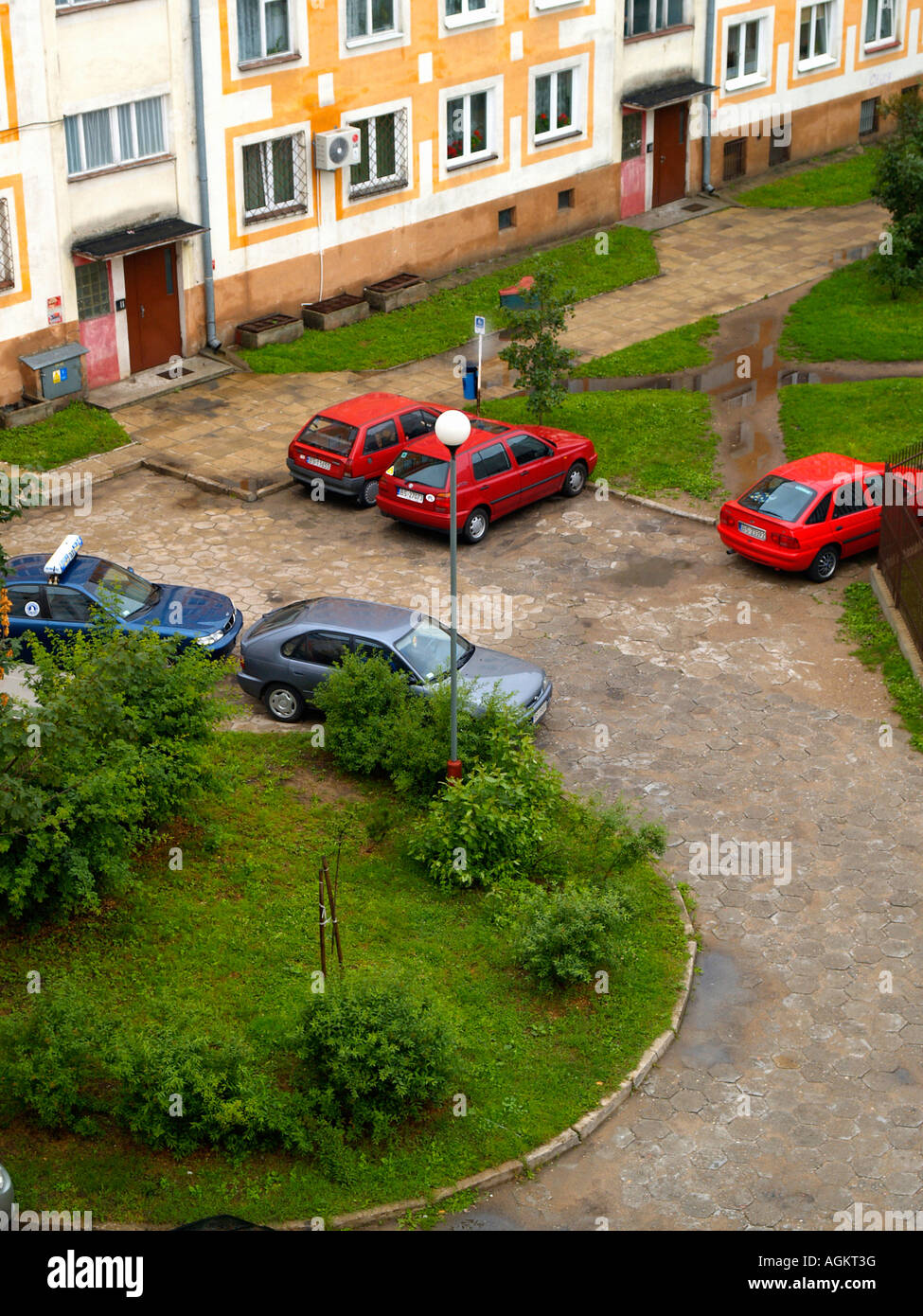 Cars parked at a small neighborhood or courtyard roundabout in front of apartment buildings in Suwalki, Poland. Stock Photo