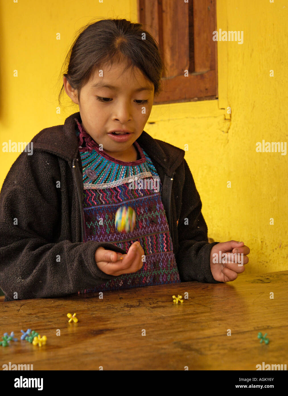Guatemala, Todos Santos Cuchumatan, Young girl playing jacks. Stock Photo