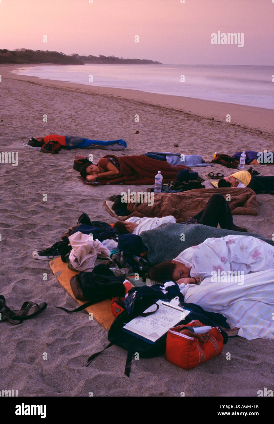 Costa Rica, Tamarindo, Volunteers with biologists resting on beach to avoid steeling eggs of Gigantic Leatherback Turtle Stock Photo