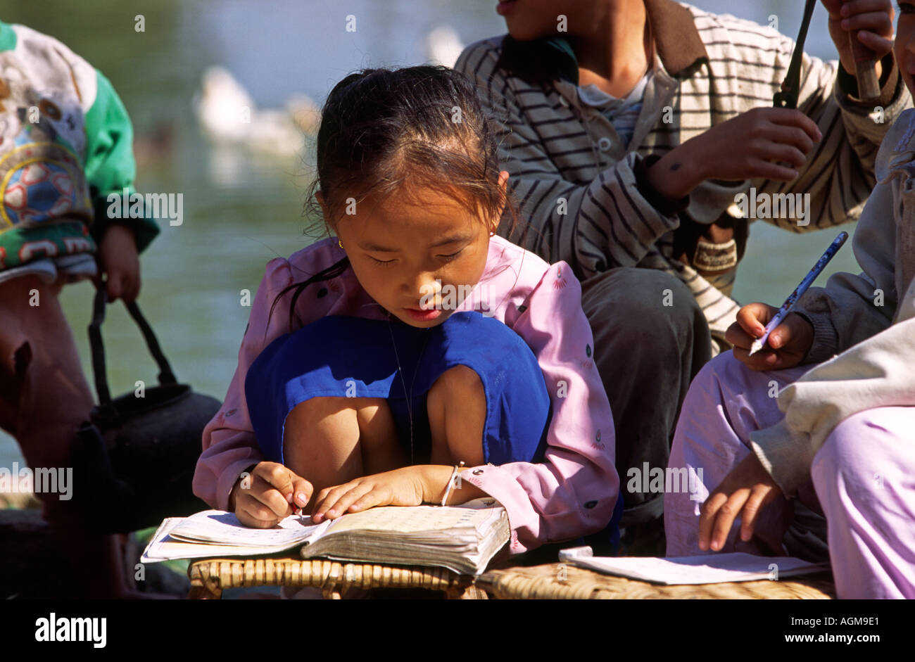 China Yunnan Xishuangbanna Gasa village young girl doing her homework learning to write Stock Photo