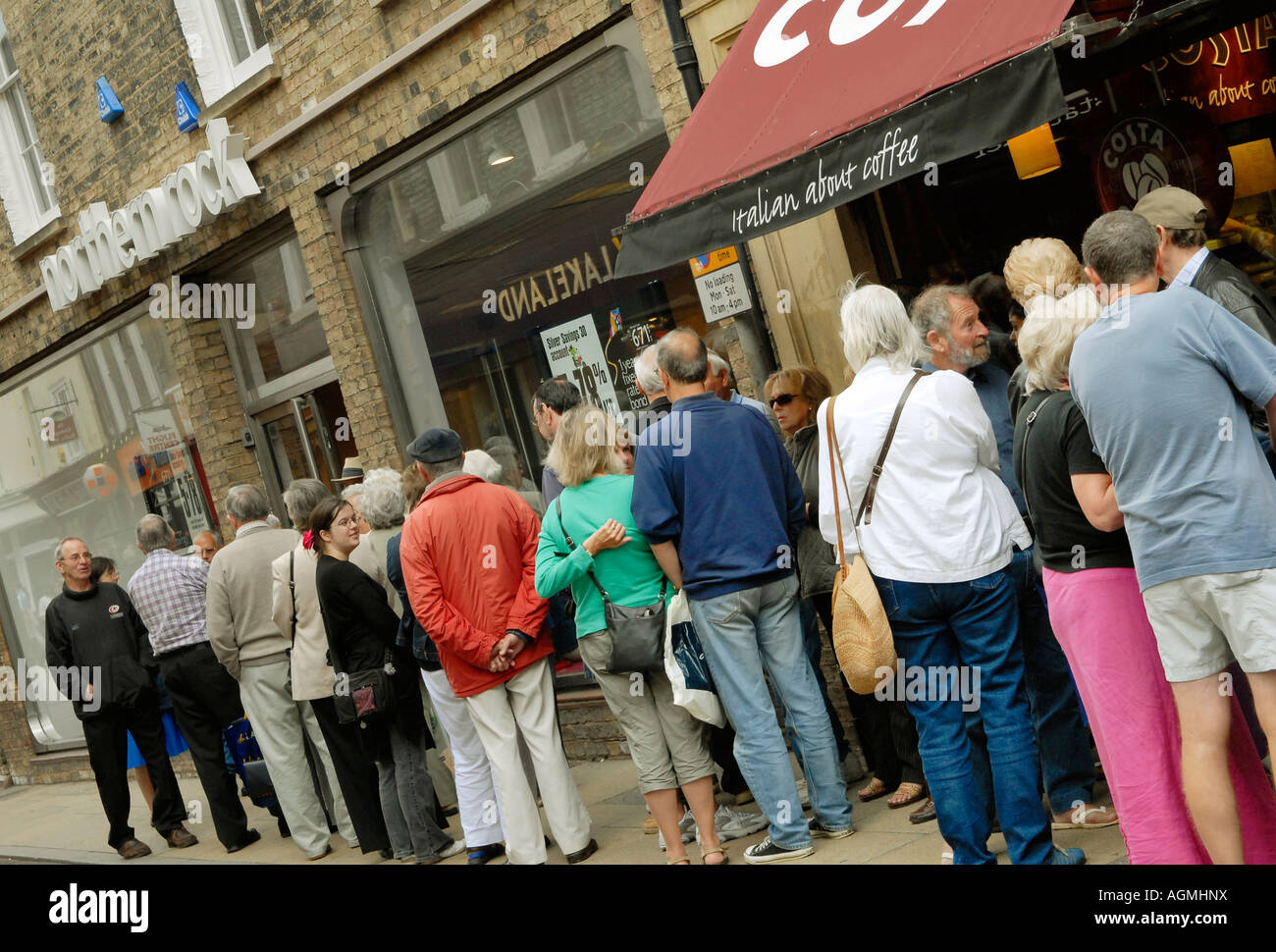 Customers queuing outside the Northern Rock Bank in Cambridge England in an attempt to withdraw their savings Stock Photo