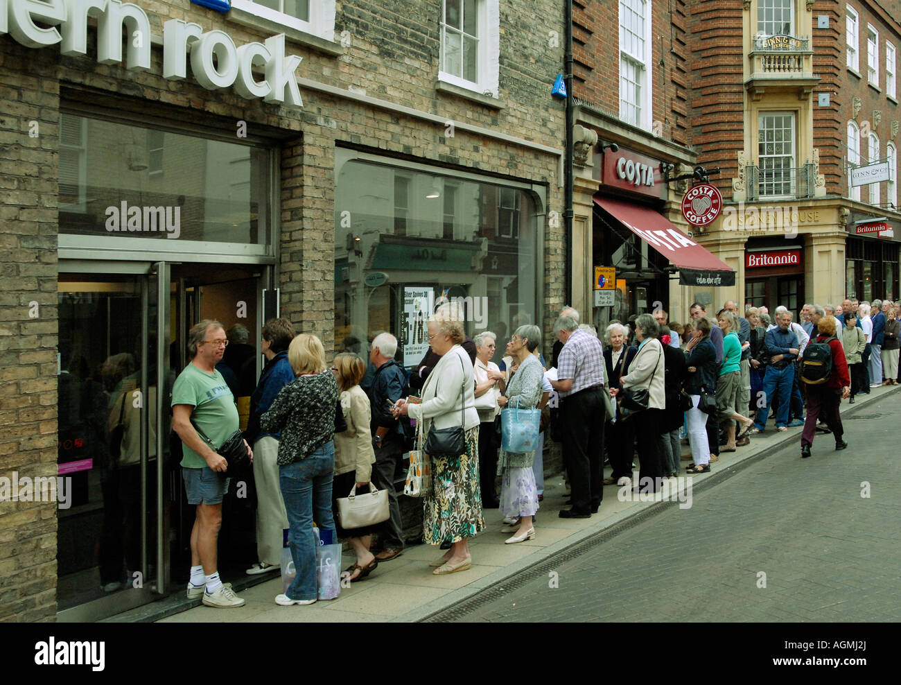 Customers queuing outside the Northern Rock Bank in Cambridge England in an attempt to withdraw their savings Stock Photo
