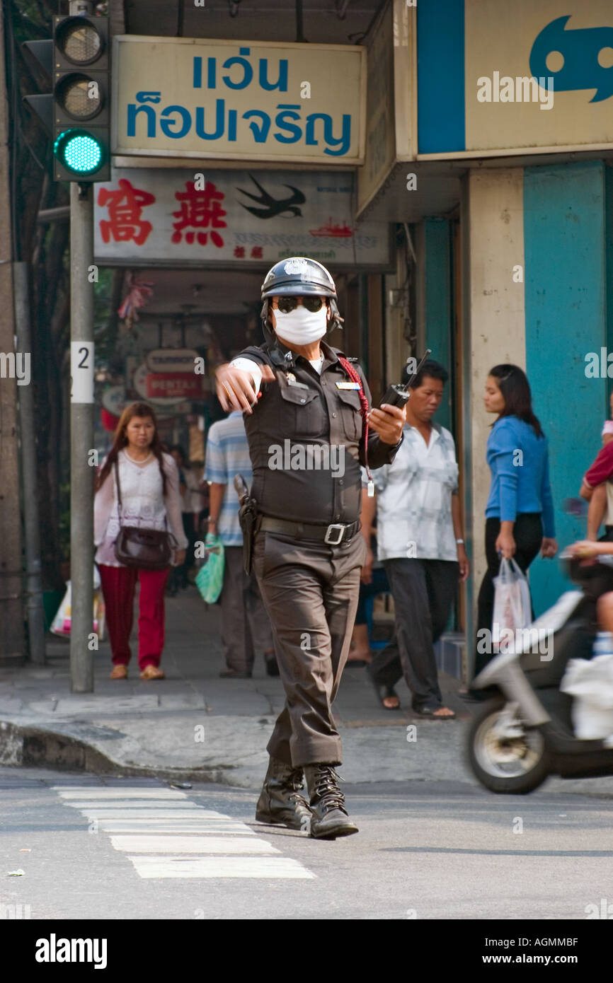 Masked Policeman directing traffic Chinatown Bangkok Thailand Stock