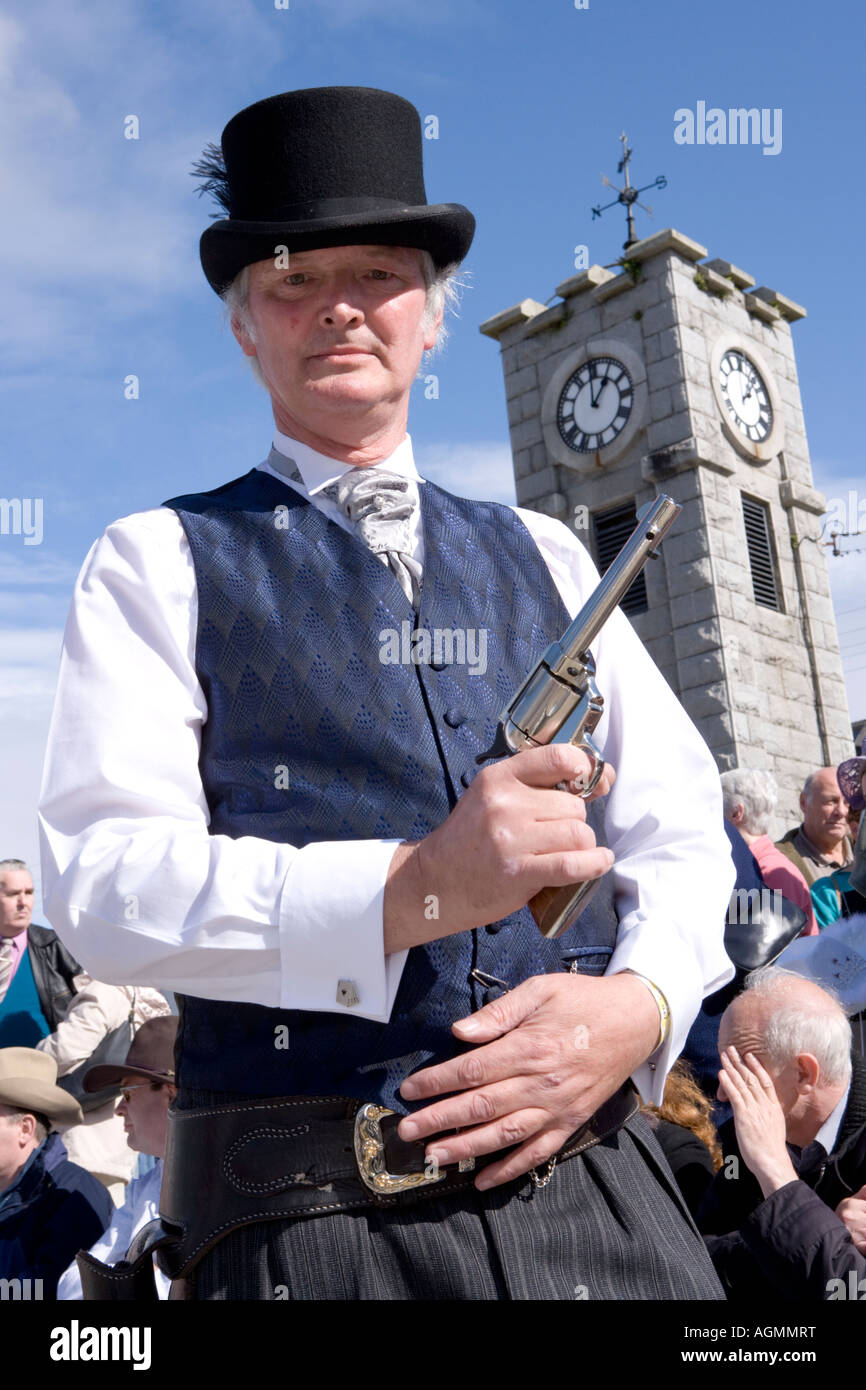 Scottish events Creetown Country Music Festival cowboy posing with gun in the Square with clock tower behind Galloway Scotland Stock Photo