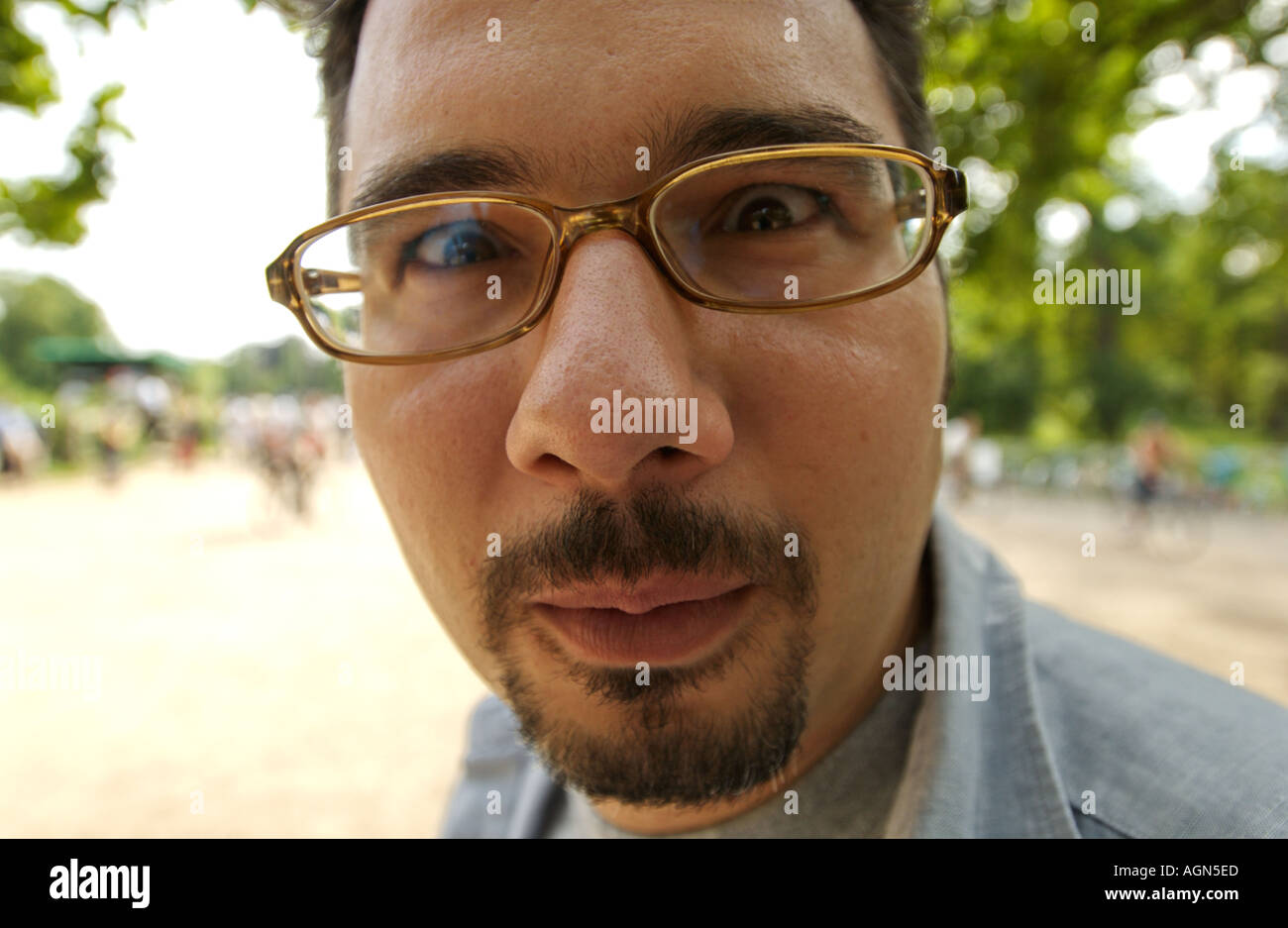 funny portrait of a man glasses moustache close up distord distorted nose big look looking Stock Photo
