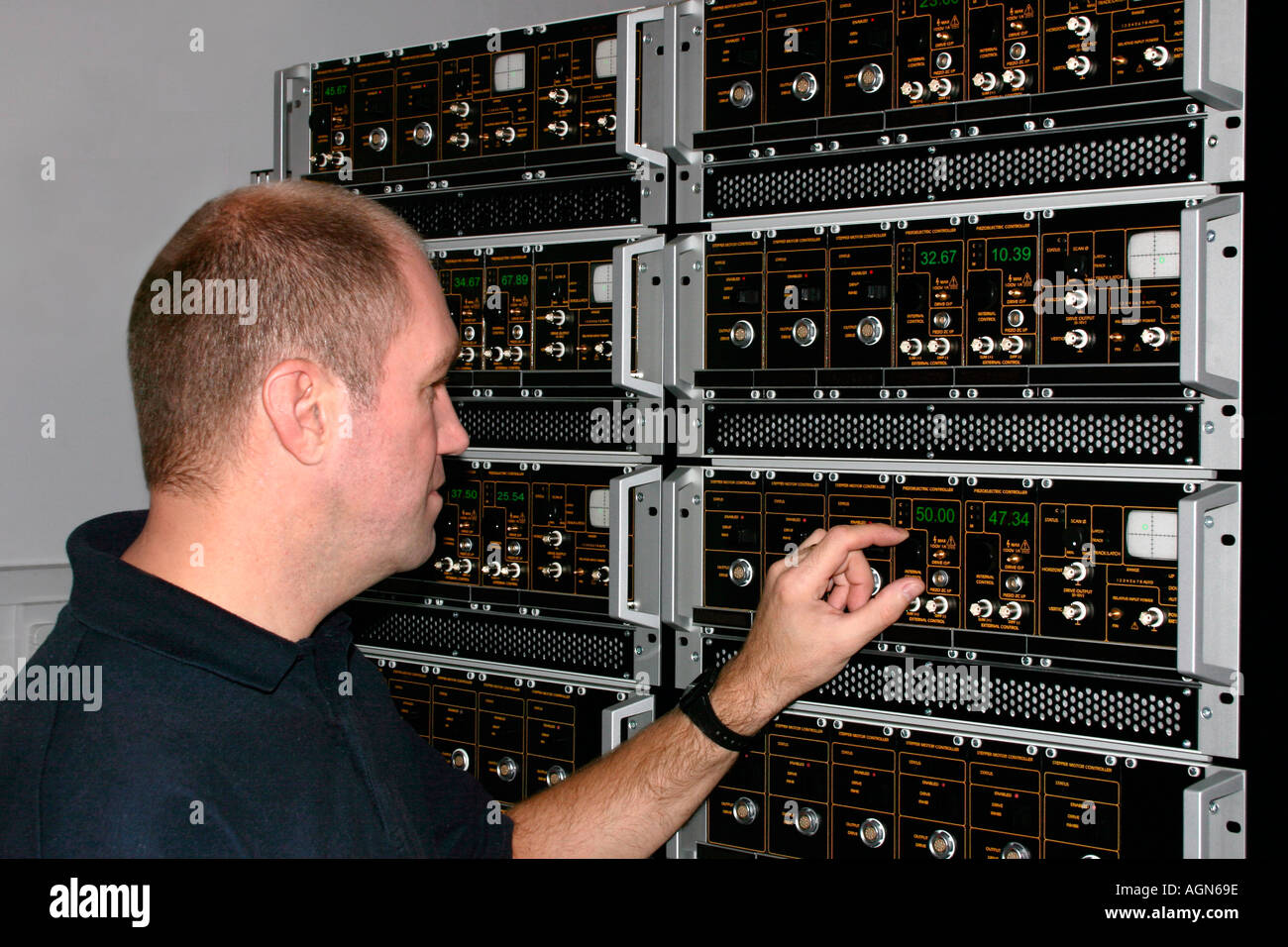A technician operating a control panel Stock Photo Alamy
