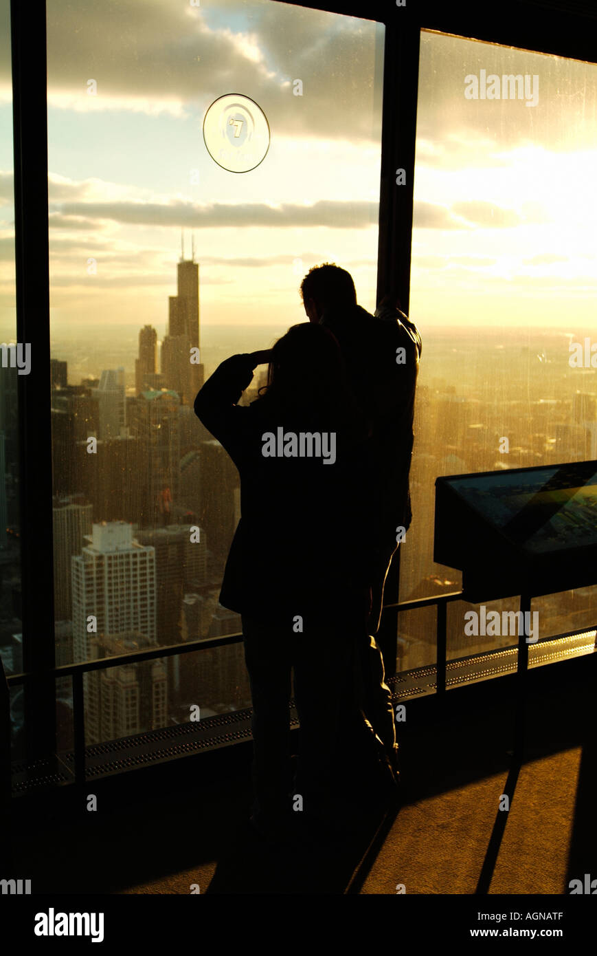 Tourists admire the view of the Chicago Skyline and the Sears Tower at sunset from the Hancock observatory Stock Photo