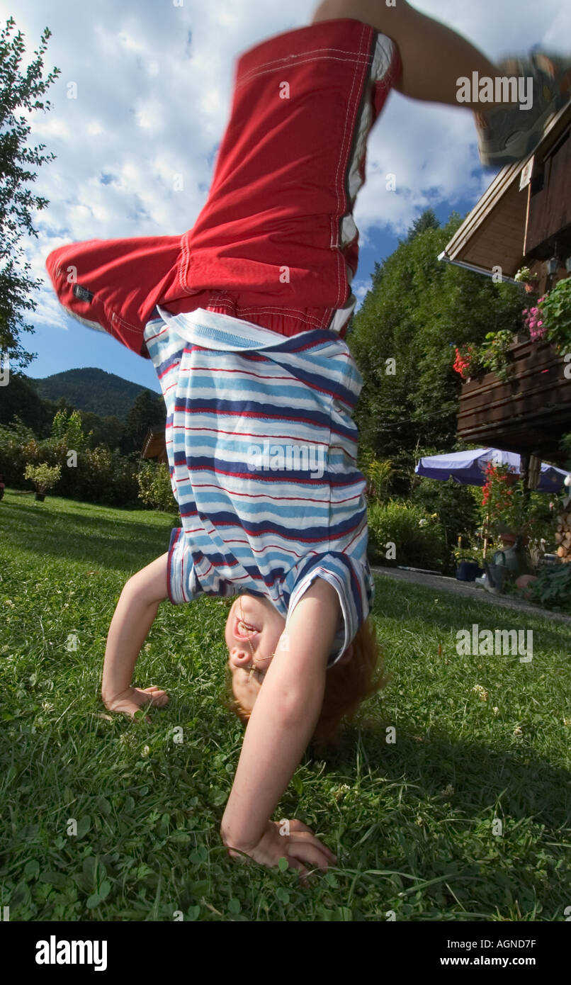 MR young boy is doing gym and a handstand in his garden Stock Photo