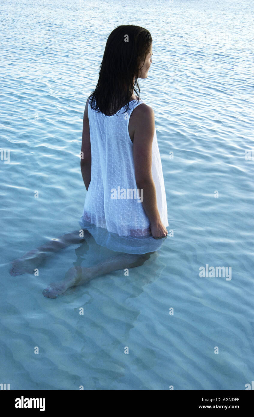 Woman standing in the water looking out to sea Stock Photo - Alamy