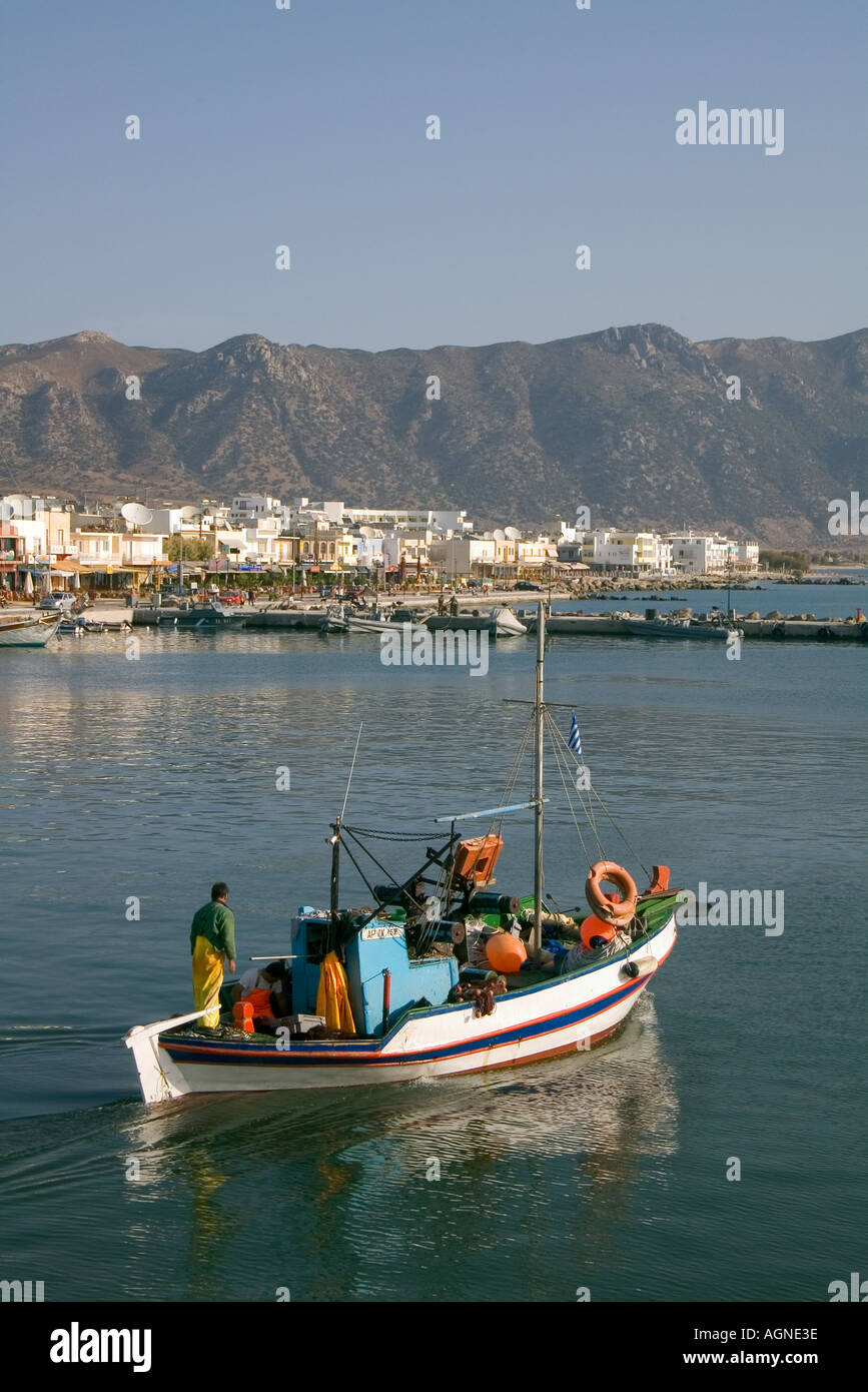 dh  KARDAMENA GREECE KOS Fishing boat departing village greek harbour people mediterranean Stock Photo