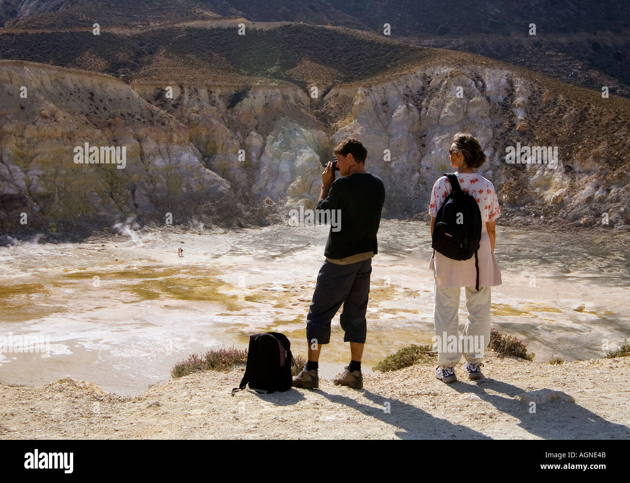 dh Stefanos volcano LAKKI PLATEAU GREECE NISYROS Adult Man woman couple tourists greek siteseeing island crater taking photograph with camera photos Stock Photo