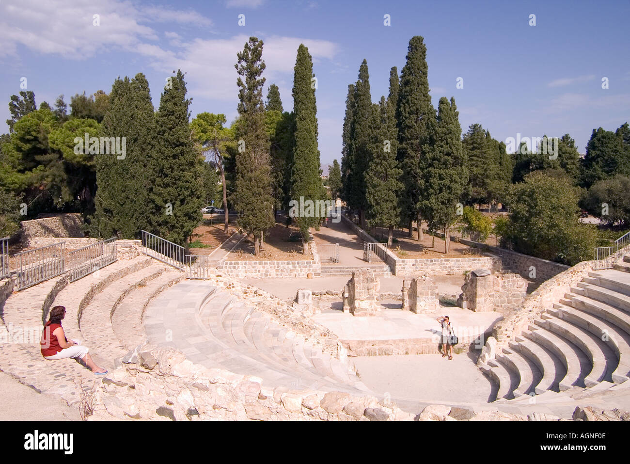 dh Odeon amphitheatre KOS TOWN KOS Tourist person taking a photograph of woman greek amphitheater seats stage roman theatre greece Stock Photo