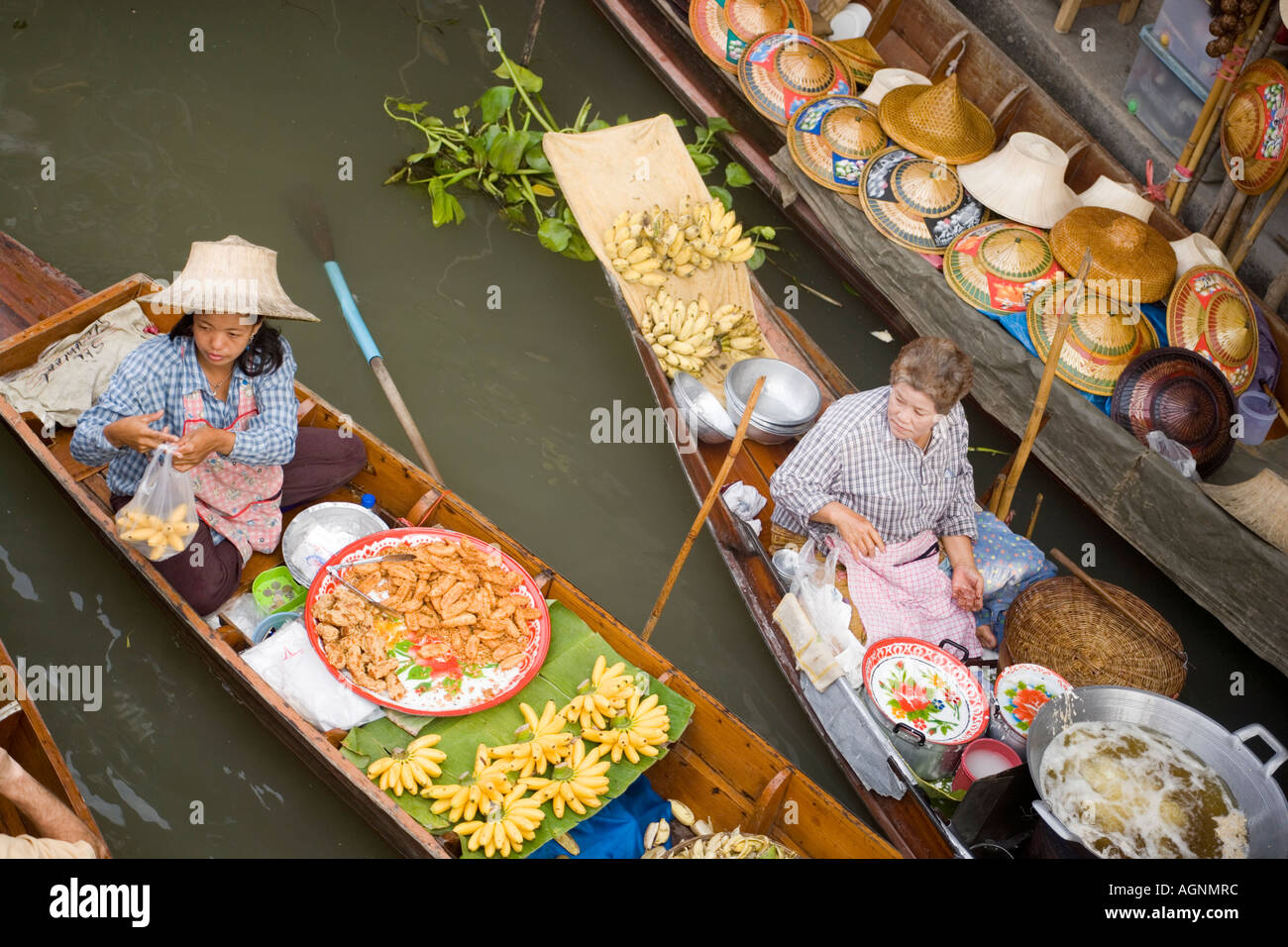 Women offering fruit at the Floating Market Damnoen Saduak near Bangkok Ratchaburi Thailand Stock Photo