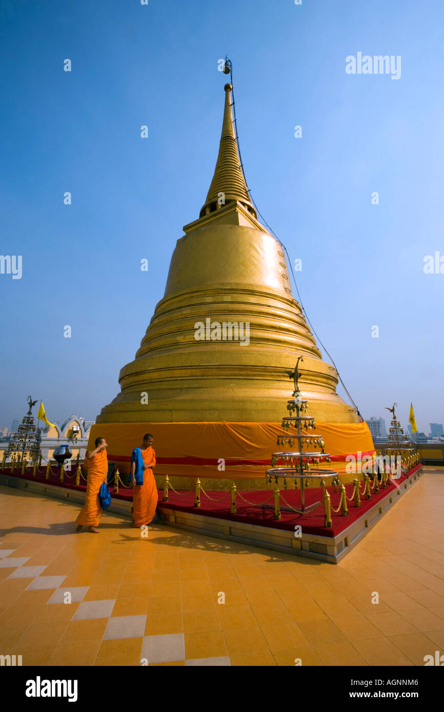 Two monks in front of gilded Chedi housed a Buddha relic of the Wat Saket on the Golden Mount Bangkok Thailand Stock Photo