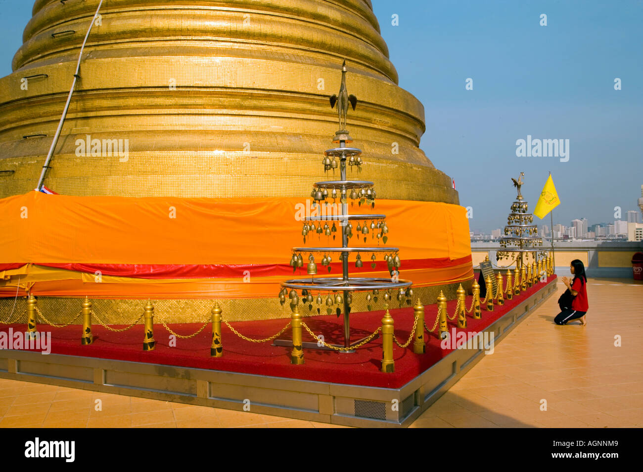 Woman praying in front of gilded Chedi housed a Buddha relic of the Wat Saket on the Golden Mount Bangkok Thailand Stock Photo