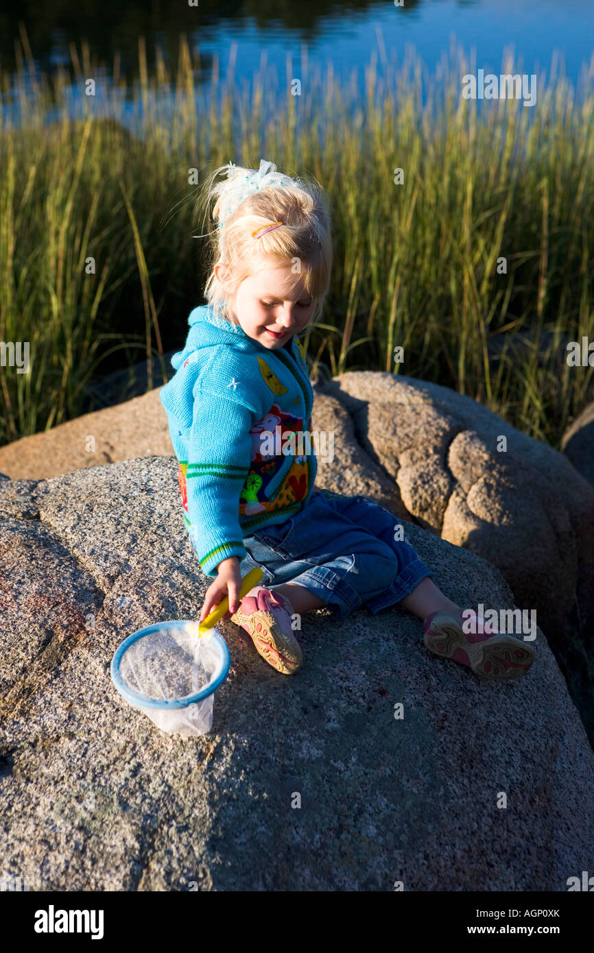 A young girl plays with a net at the Goose Cove preserve in Glouecster Massachusetts Essex County Greenbelt Association Stock Photo