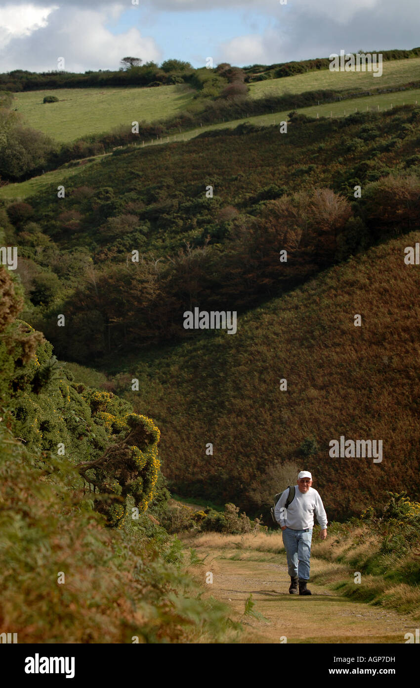 An elderly man walking on the path from Heddon Valley towards Woody Bay Stock Photo