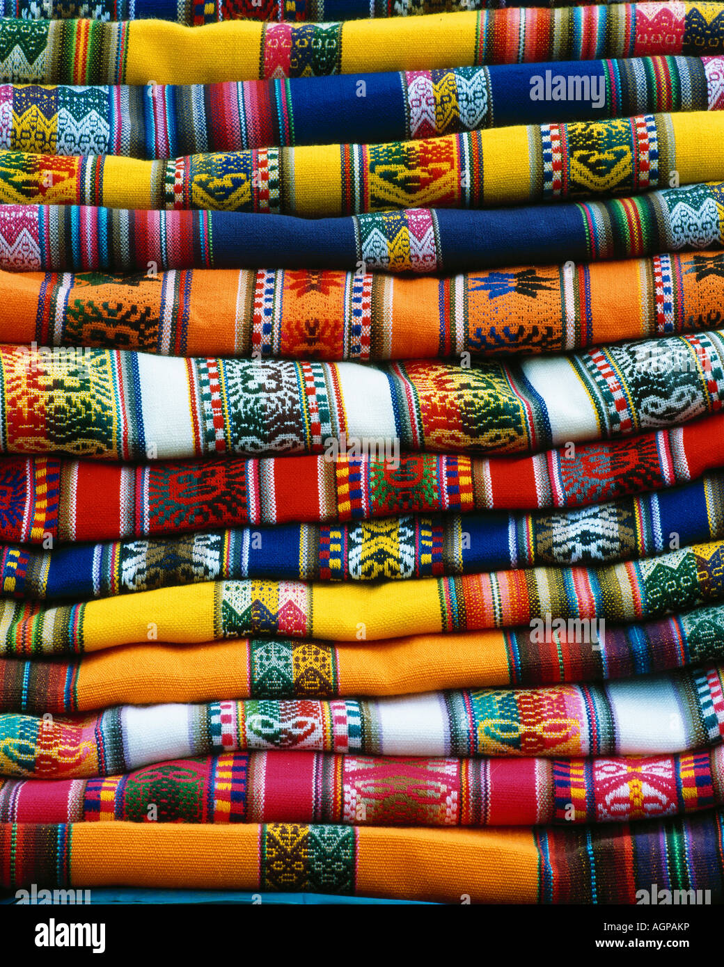 South America, Peru, near Cusco. Stack of colorful blankets for sale in