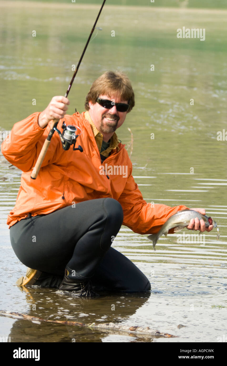 Alaska Southwest Fisherman releasing Grayling fish on Nuyakuk Lake Wood-Tikchik Sate park Stock Photo