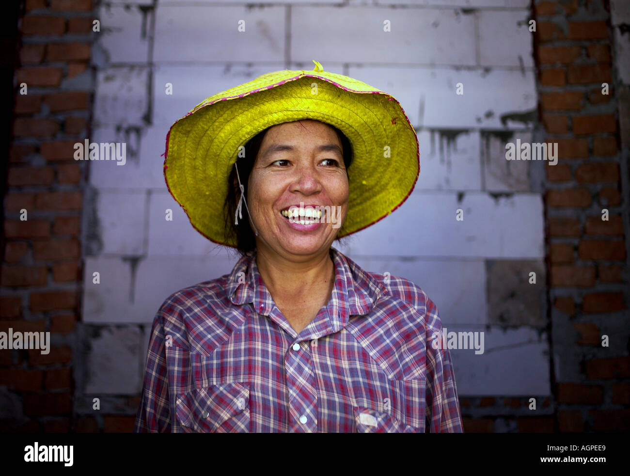 Elderly Asian woman wearing yellow straw hat and smilling Bangkok Thailand Stock Photo