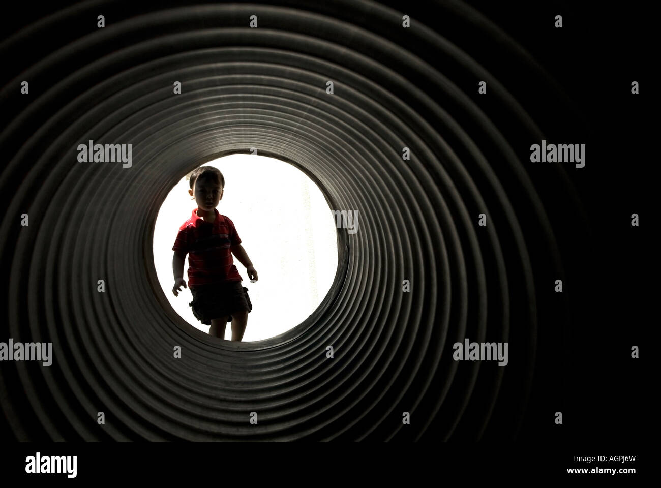 A boy looks through a tunnel Stock Photo