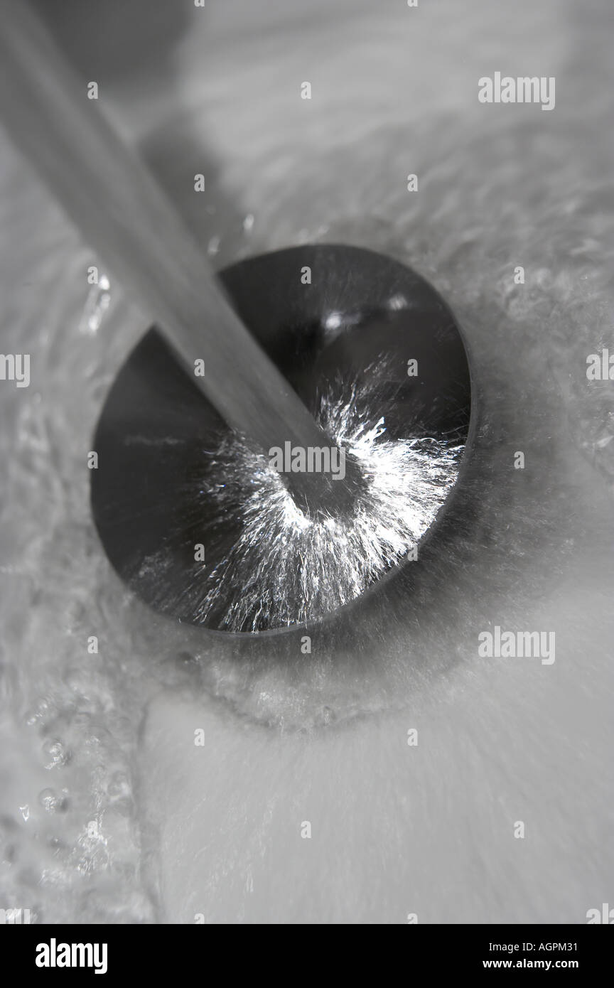TAP WATER POURING DOWN PLUG HOLE IN WHITE BATHROOM SINK Stock Photo Alamy