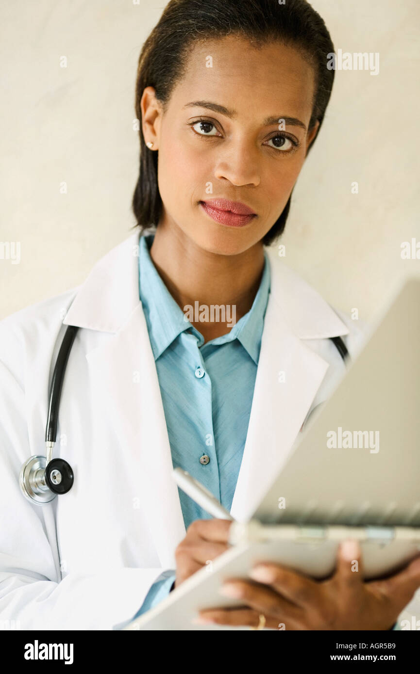 Portrait of female doctor writing in chart Stock Photo - Alamy