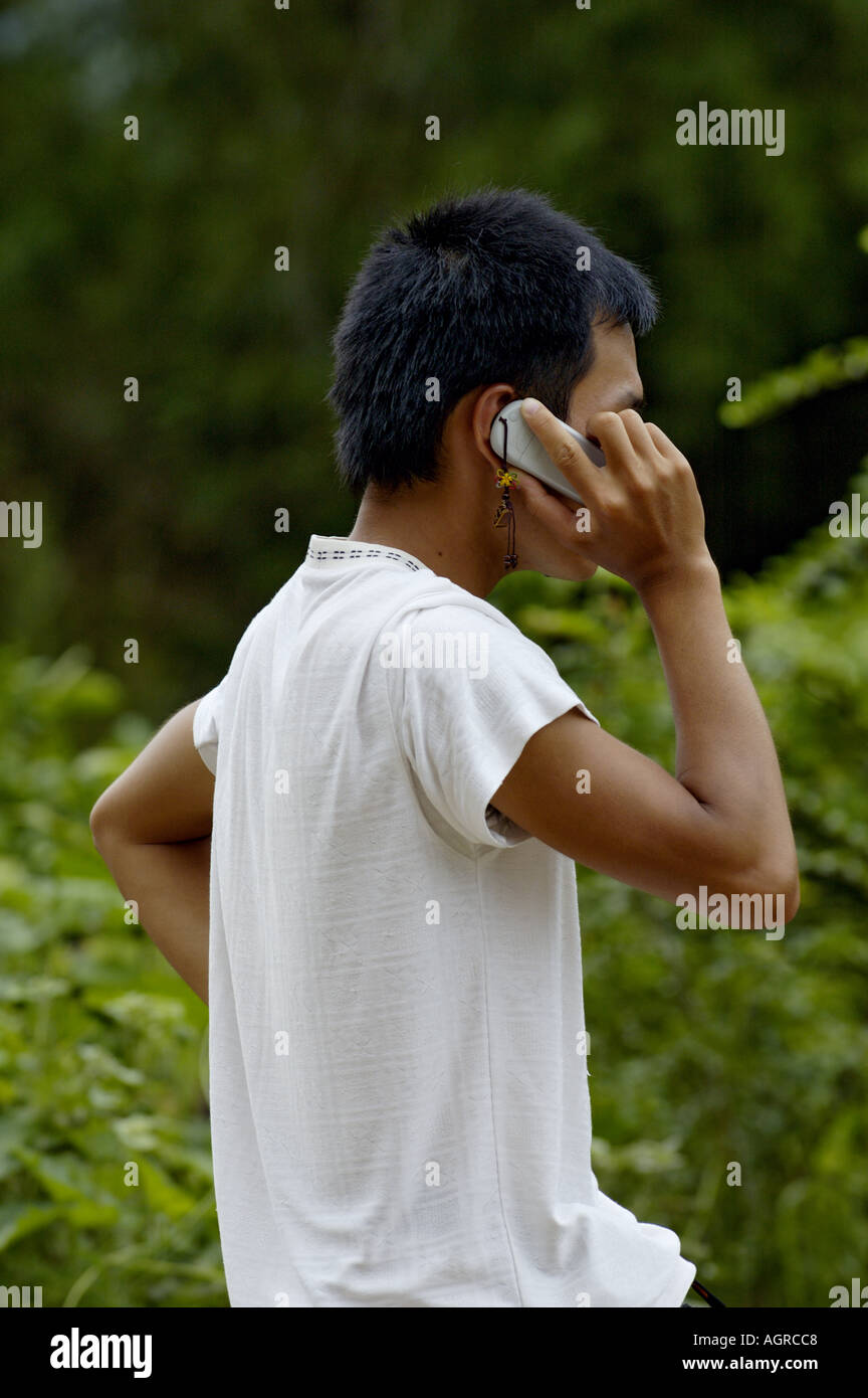 Young man talking on a mobile phone in the countryside, Yangshuo, Guangxi, China. Stock Photo
