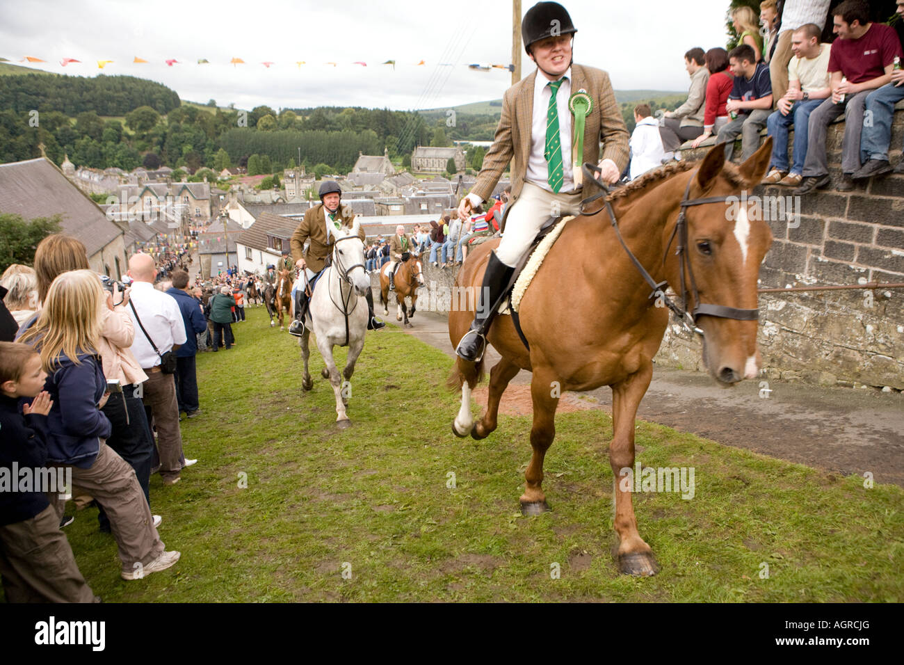 Scottish traditional events Langholm Common Riding horses riding up Kirk Wynd with the crowd cheering them on Scotland UK Stock Photo
