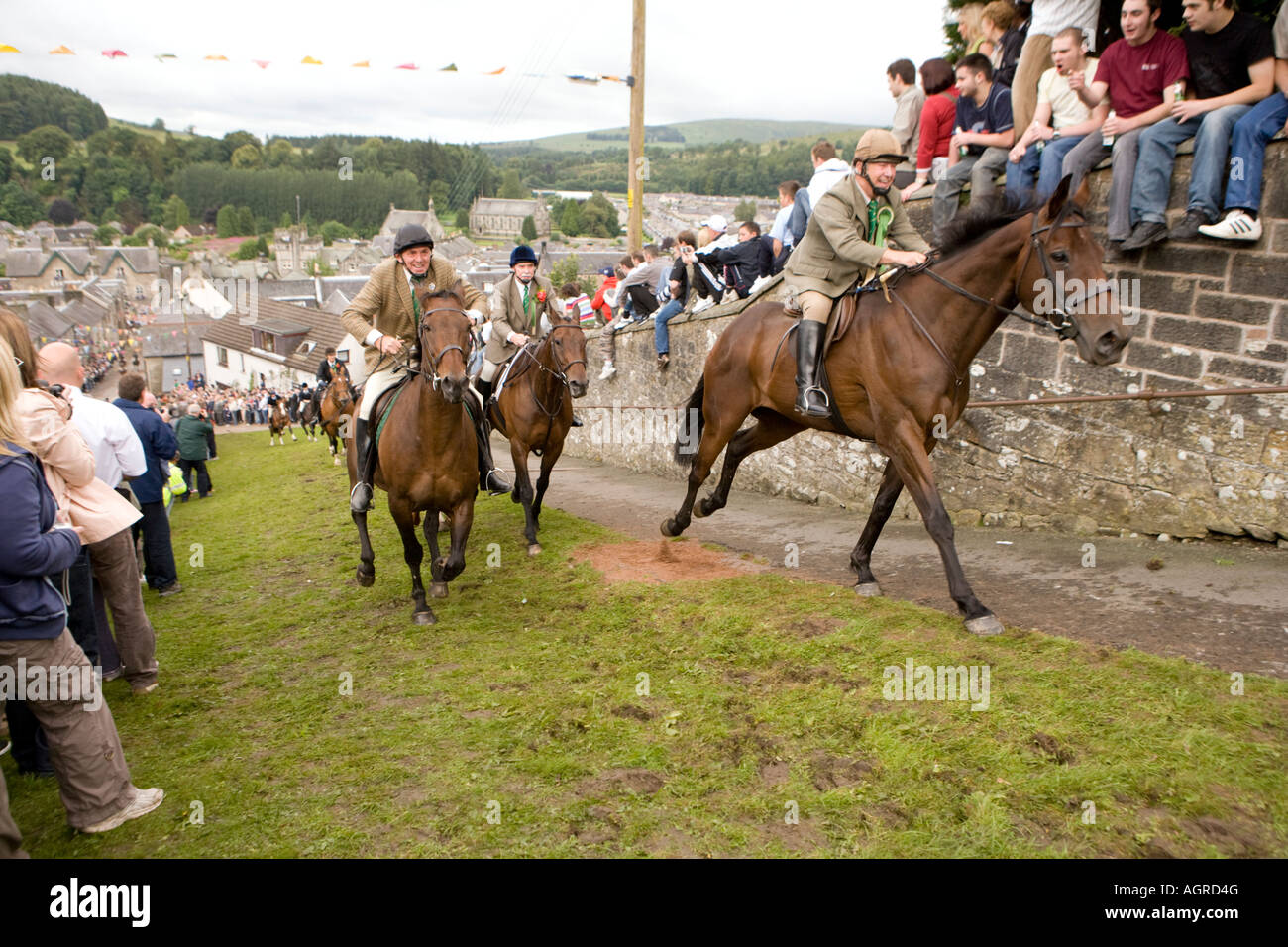 Scottish traditional events Langholm Common Riding horses riding up Kirk Wynd with the crowd cheering them on Scotland UK Stock Photo