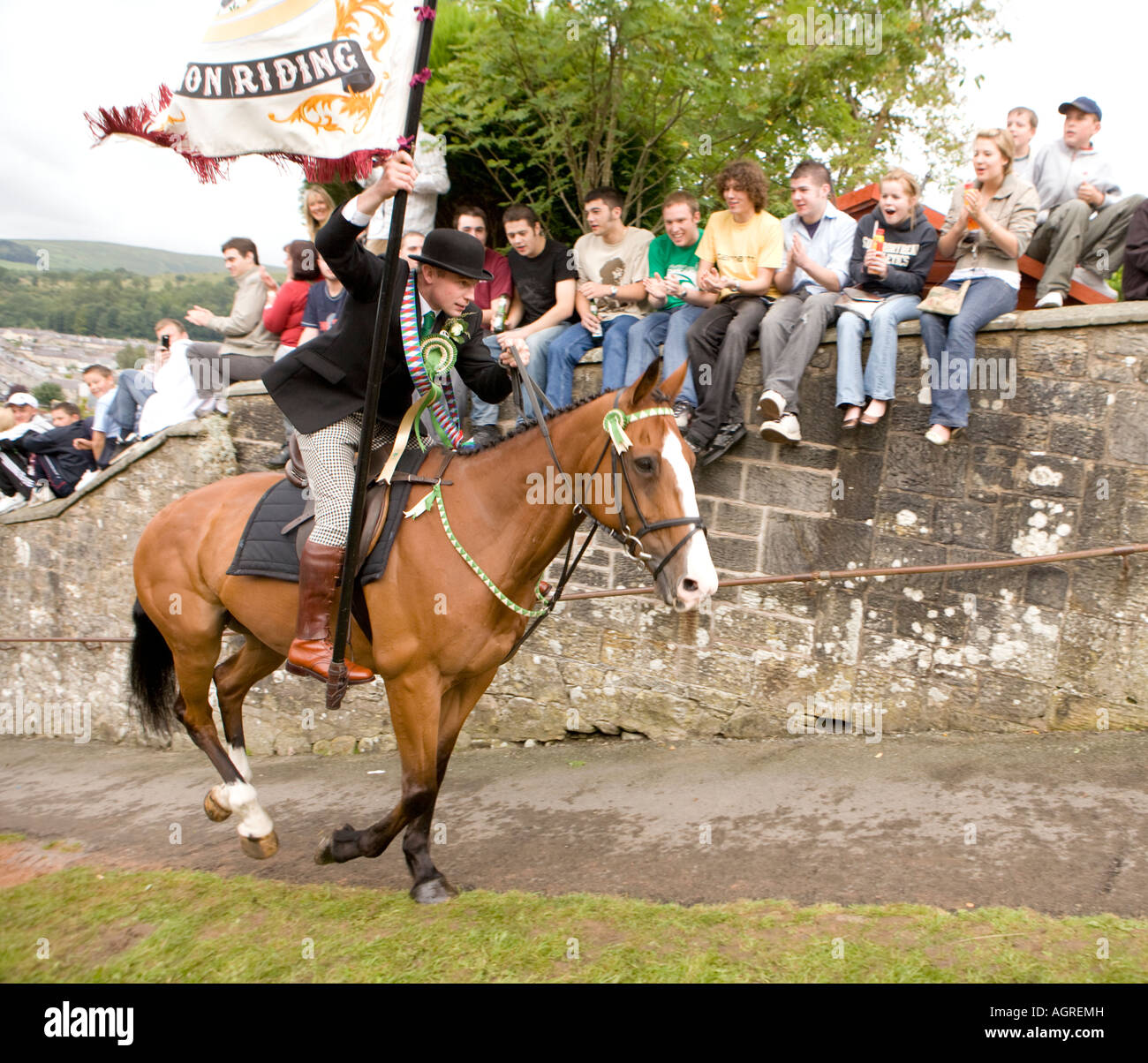 Traditional Scottish event Langholm Common Riding cornet charging on horse back up Kirk Wynd with flag Eskdale Scotland UK Stock Photo
