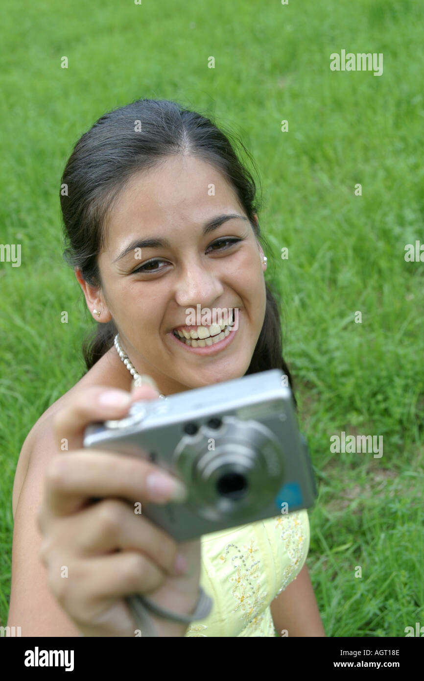 Portrait of a smiling young woman looking up using a digital camera Stock Photo
