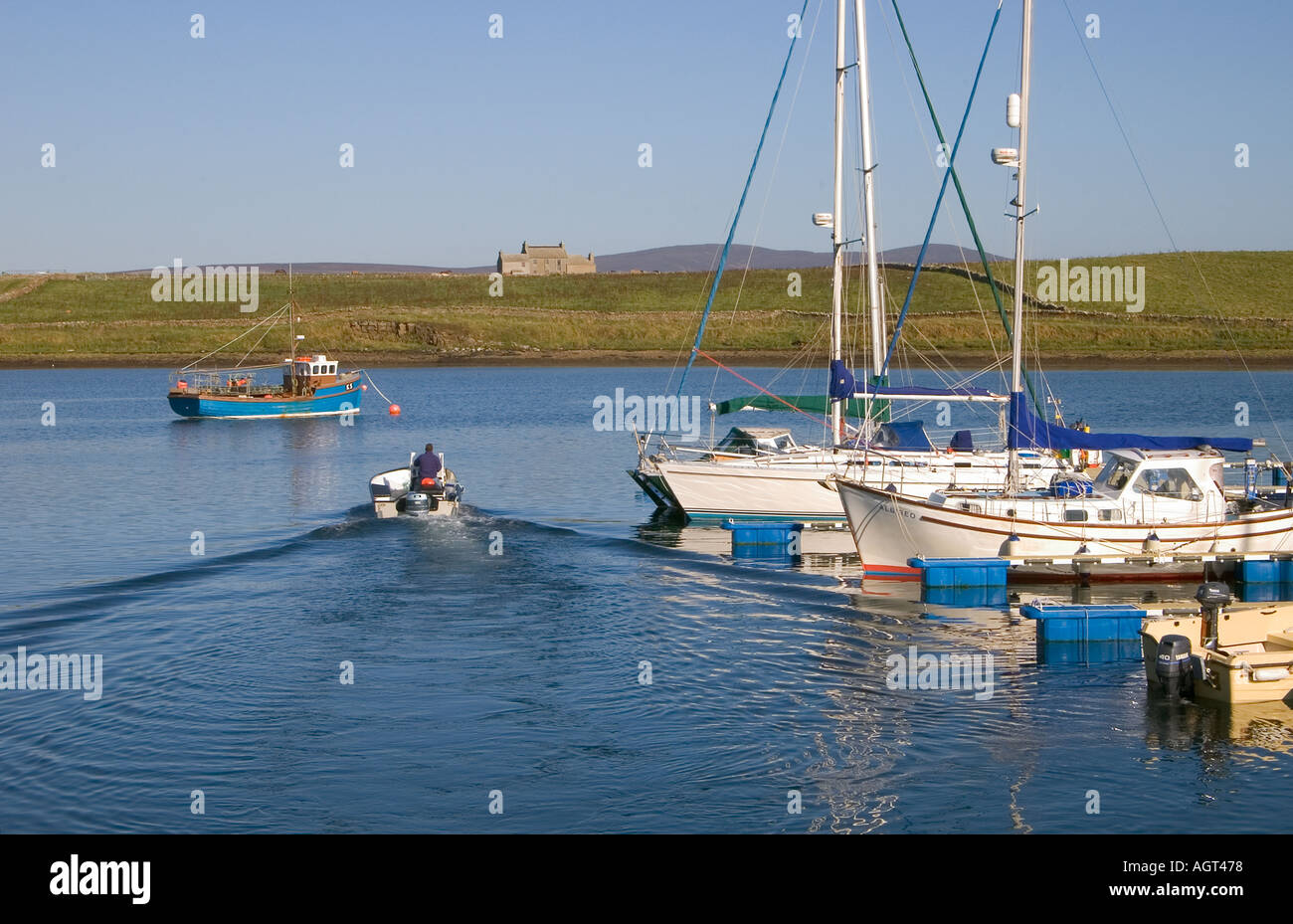 dh Marinas jetties STROMNESS MARINA ORKNEY SCOTLAND Motor boat leaving yachts harbor boats in jetty yacht anchorage uk Stock Photo